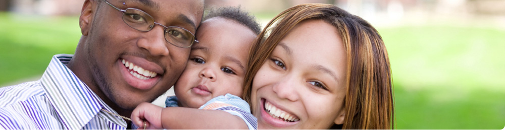 A couple holding a baby between them.